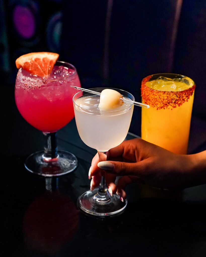 Image pop-up Three colorful cocktails with citrus and fruit garnishes served at Flanker.
